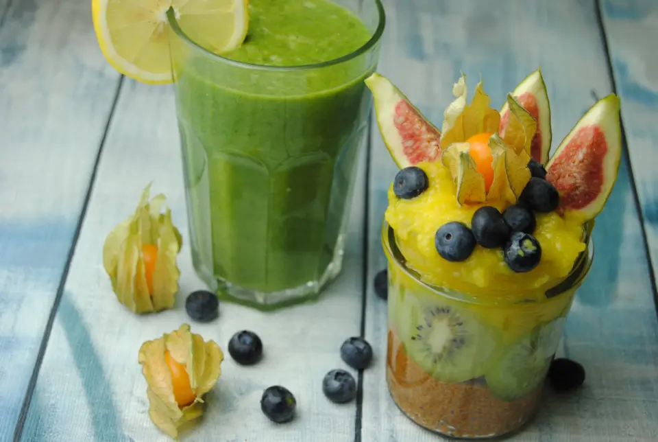 Chia Pudding Frühstück Chia Pudding mit Kiwi und Mangocreme als gesundes Frühstück neben grünem Smoothie